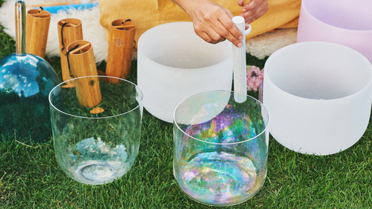 Person playing a set of multicolored crystal singing bowls, creating harmonic sound vibrations used in sound healing practices, 432 Hz resonance, and solfeggio frequencies for mind, body, and spirit balance